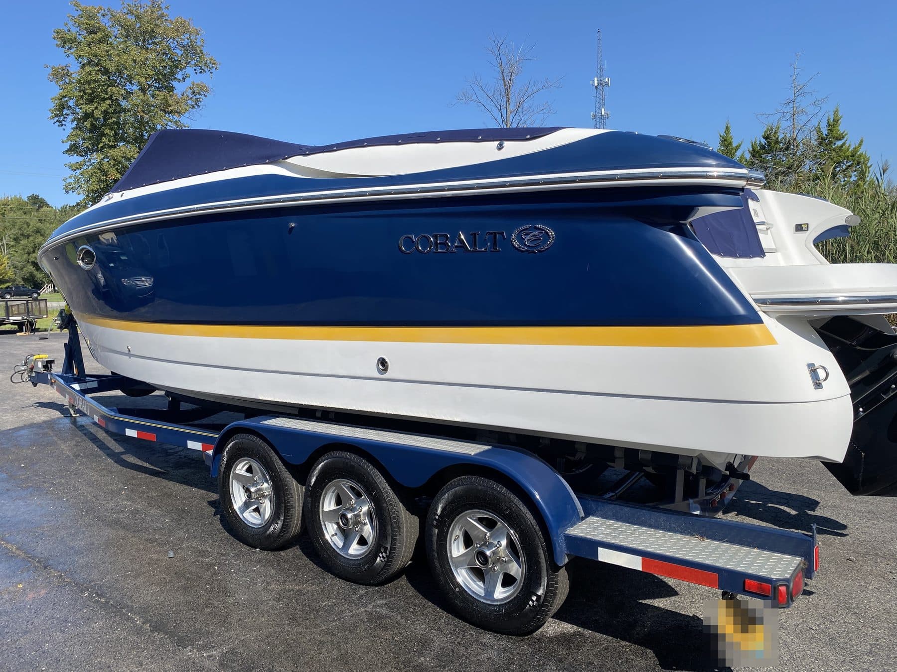 A blue Cobalt boat on its trailer after a full detail, gelcoat deep and glossy