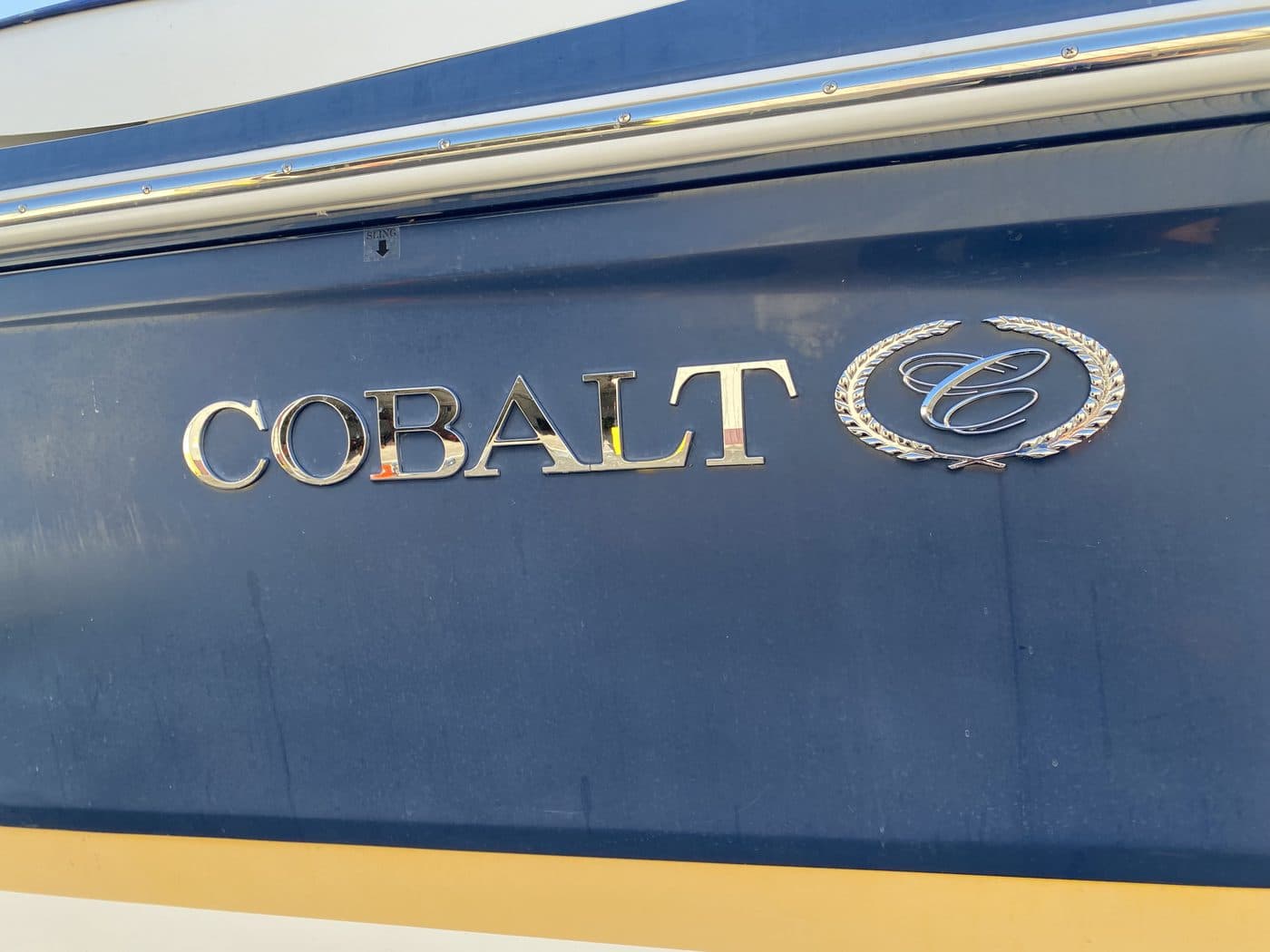 Faded chalky blue gelcoat around a Cobalt badge