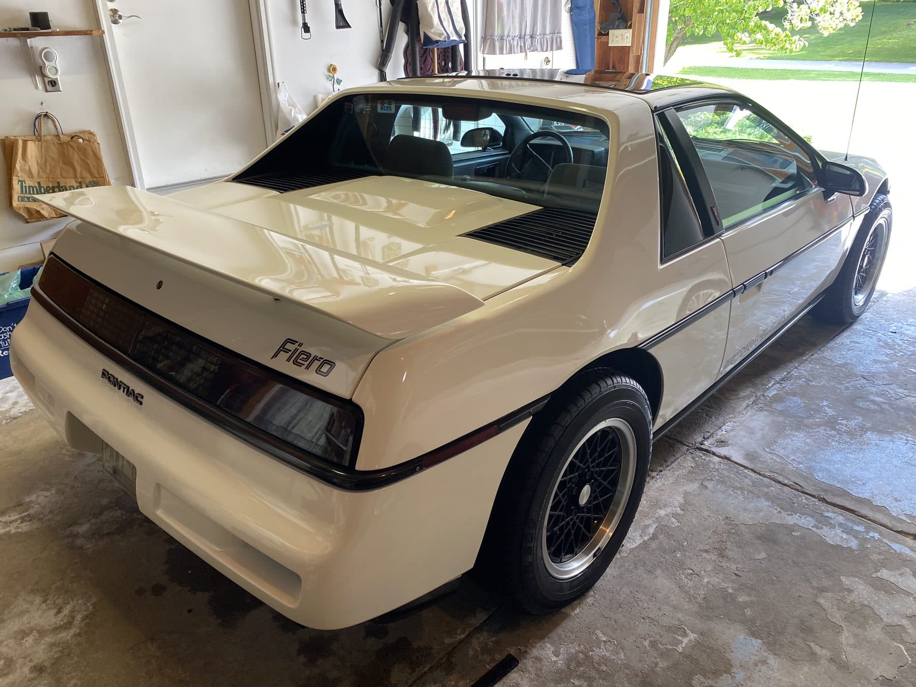 Cream Pontiac Fiero in a garage