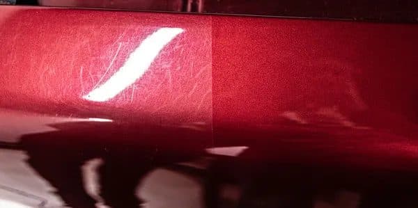Red paint with swirl marks on the left and corrected paint on the right